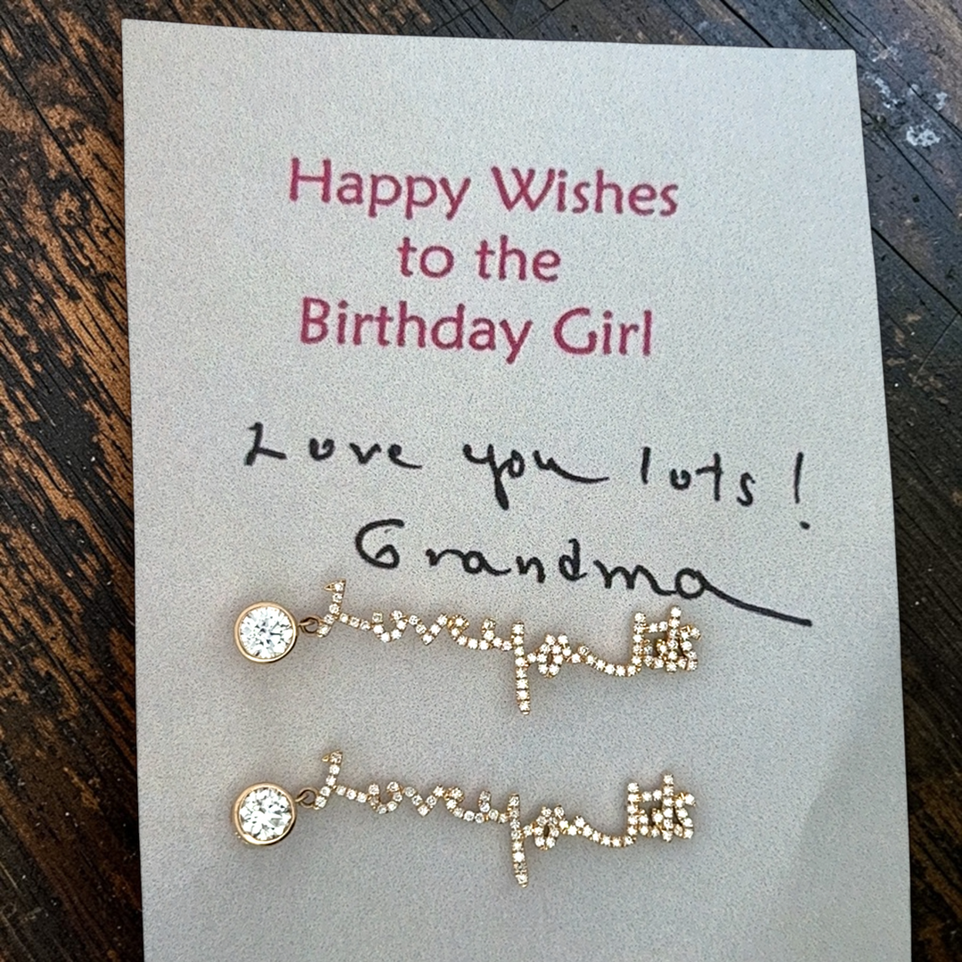 Your handwritten words gleam from ear to ear,
Your message in gold forever to hear

Your unique handwritten earrings in thick 14K gold, encrusted in pave diamonds, dangle from sparkling half carat diamond studs